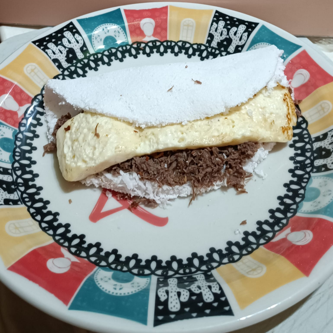 Massa, coco ralado, carne de sol desfiada e queijo coalho