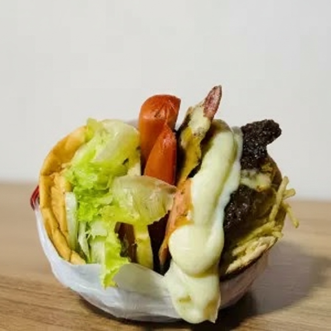 Pão, hambúrguer, salsicha, presunto, mussarela, ovo, alface, tomate, abacaxi, milho e batata.