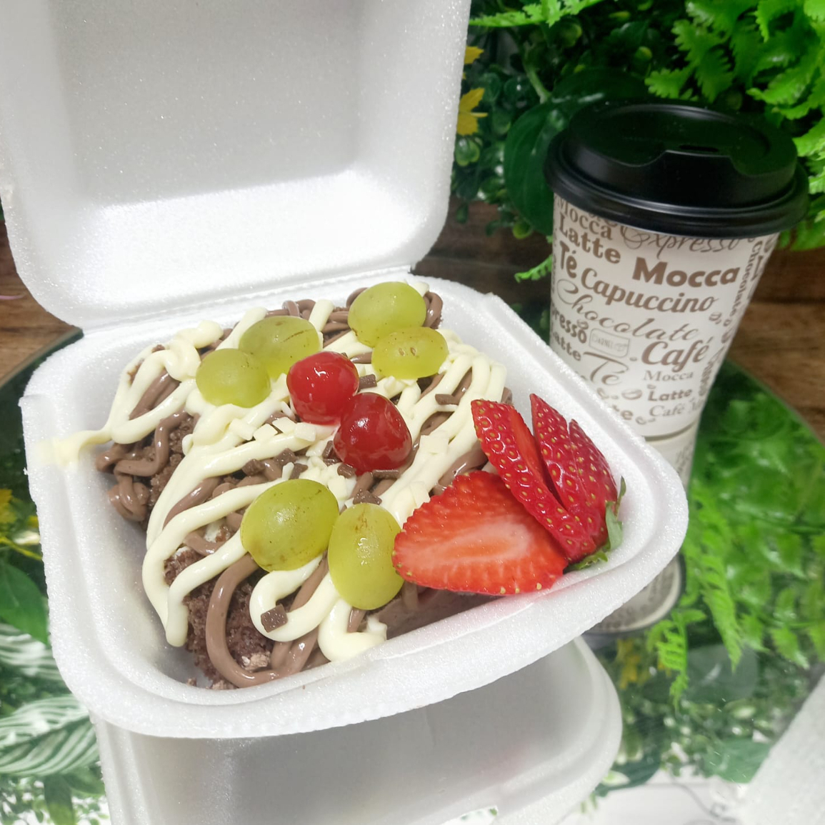 Bolo de chocolate trufado Preto e Branco com cobertura de Ninho cremoso e brigadeiro cremoso, frutas como morangos frescos, cerejas e uvas para finalizar. Pesando 350 gramas essa fatia serve bem 2 pessoas