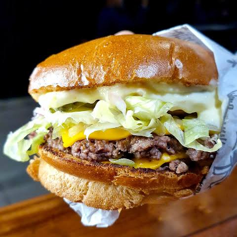 pão selado na chapa, maionese artesanal, 3 hamburguer (artesanal), queijo mussarela sob os tres, alface, tomate, milho.