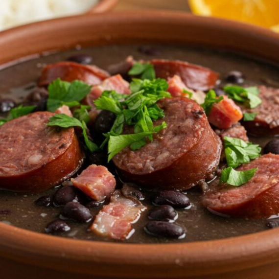 Marmita contendo arroz, feijoada e farofa, acompanha torresmo pururuca e vinagrete separada.
foto ilustrativa.