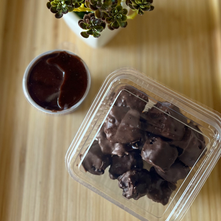 Pedaços de brownie coberto com chocolate e acompanha um delicioso creme