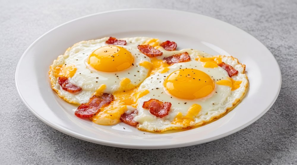 Huevos fritos con tocineta y queso.