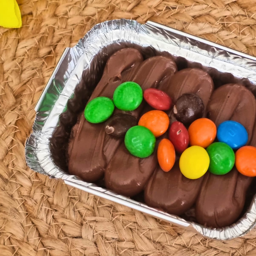 Brownie bem chocolatudo coberto com brigadeiro gourmet e M&M's