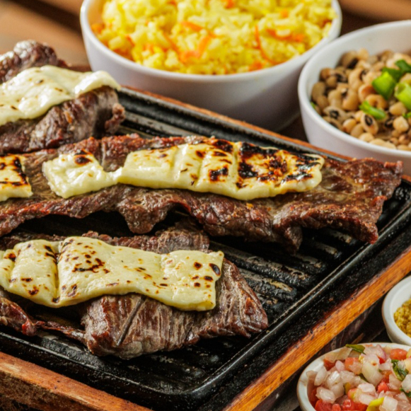 Carne de Sol, acompanha arroz acenourado, feijão macassar, batata maionese, vinagrete e farofa.