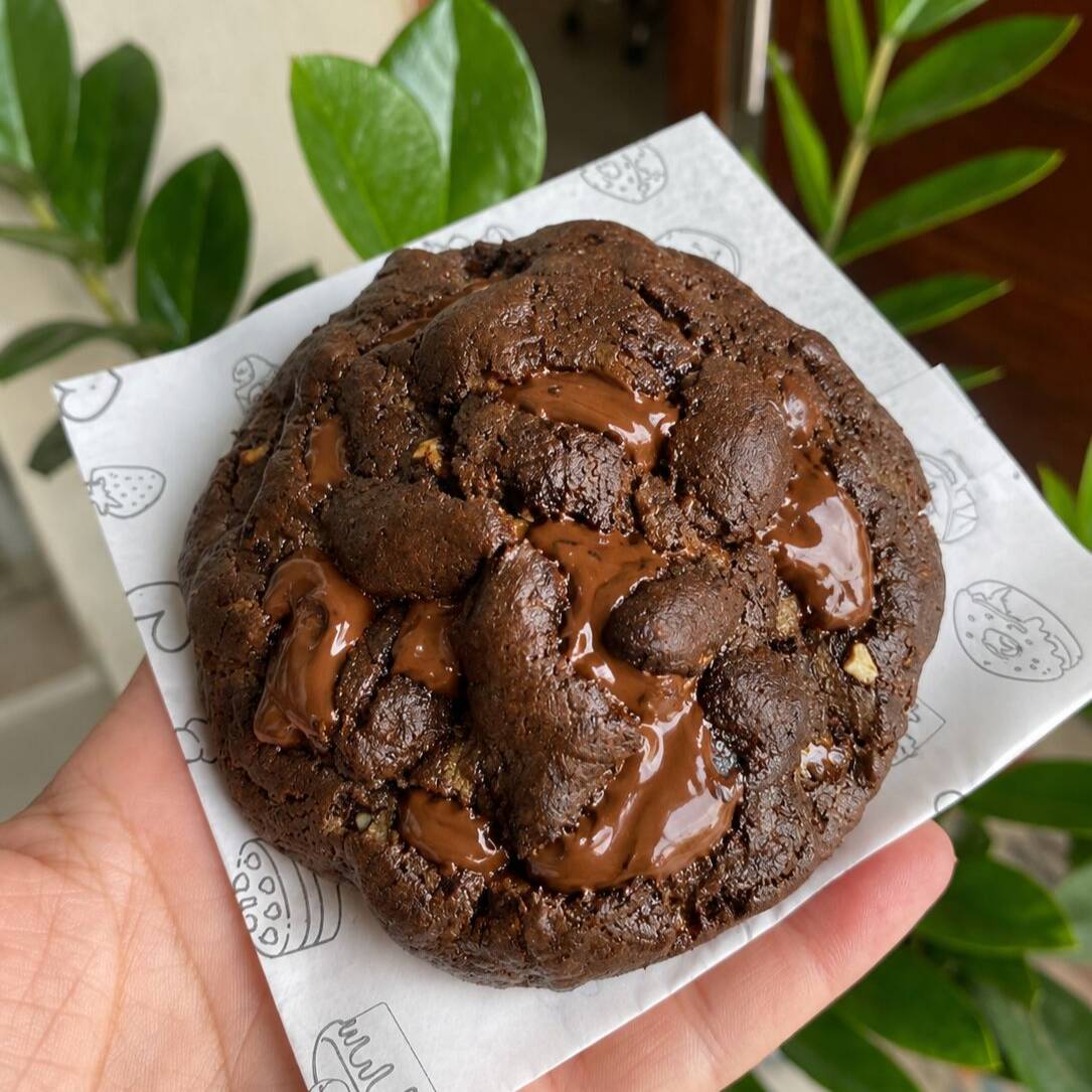 Cookie chocolatudo, a massa feita com cacau 100% e black, com 3 tipos de cholotate em gotas nobre: branco, blend e meio amargo, para ficar melhor ainda, muitoooo recheio de brigadeiro ao leite. Feita com manteiga de verdade e gotas de chocolate nobre, textura perfeita e irresistível!