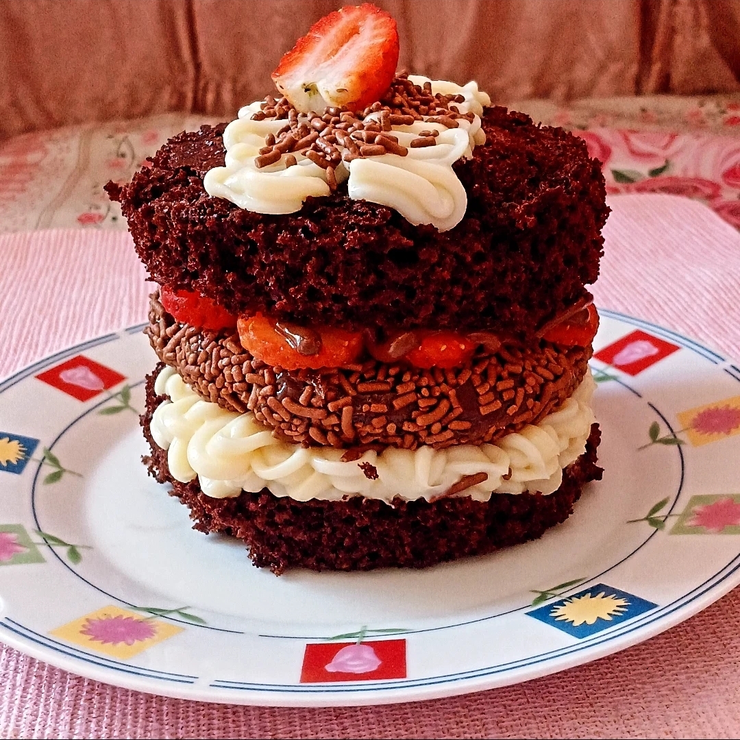 Delicioso bolo de chocolate, com uma camada de brigadeiro cremoso de leite Ninho, um hambúrguer de brigadeiro, morangos frescos picados e Nutella.