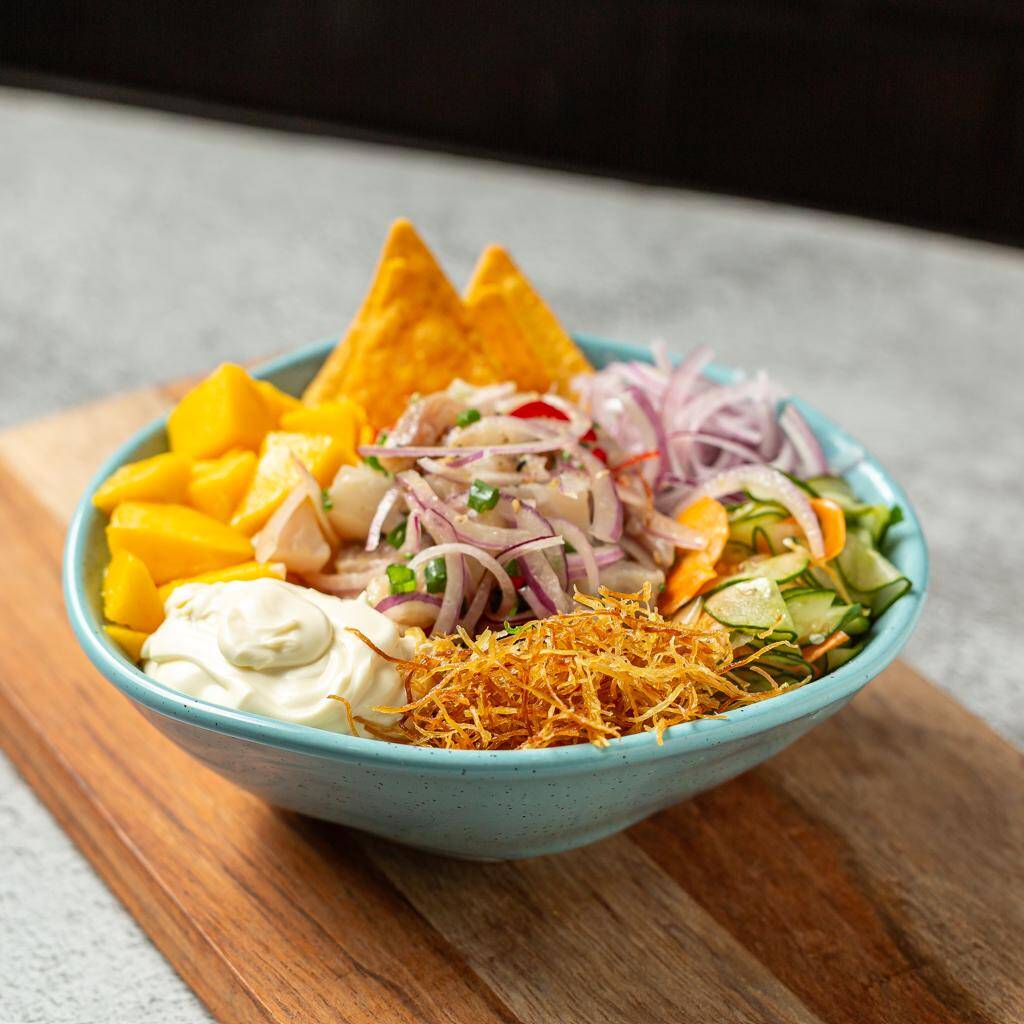 Base arroz Japonês, Pedacinhos de Manga em Cubos, Cebola Roxa, Pepino Fatiado, Chips de Batata, Cream Cheese, Doritos e Tilápia em Cubos Cru. Finalizado com Mix de gergelim.