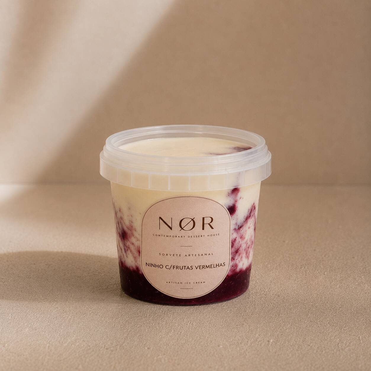 Ninho c/ Frutas Vermelhas
Sorvete de leite Ninho, com sabor marcante de leite, combinado no pote com geleia artesanal de frutas vermelhas. A geleia é preparada na NØR com frutas naturais, criando um contraste entre a cremosidade do leite e a acidez das frutas.