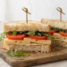 Pão de forma super macio selado com uma camada cremosa de requeijão, fatias generosas do legítimo queijo meia cura furadinho, rodelas suculentas de tomate fresquinho e folhas verdes selecionadas à sua escolha.