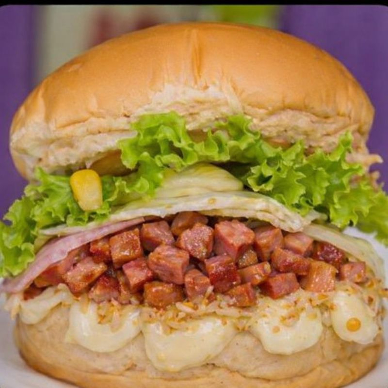 Pão gourmet, calabresa, hambúrguer artesanal alto de 150 gramas, queijo, presunto, milho, ervilha, tomate, alface e maionese caseira