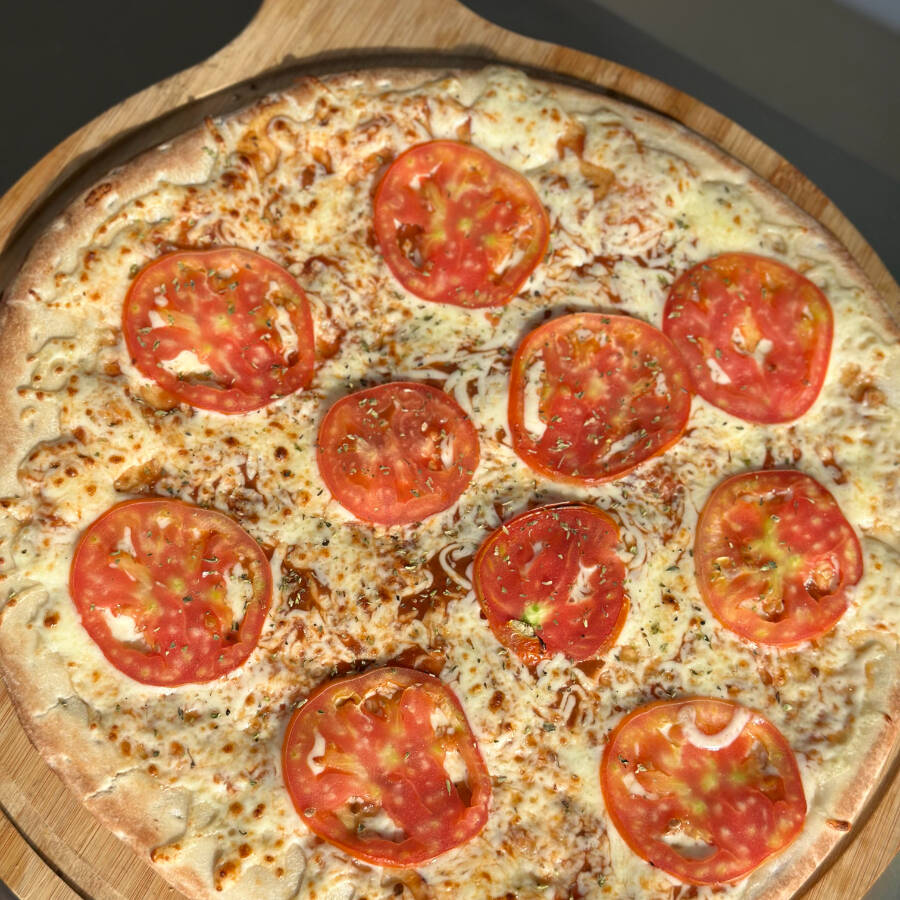 Massa artesanal, molho de tomate, queijo mussarela, tomate e orégano.