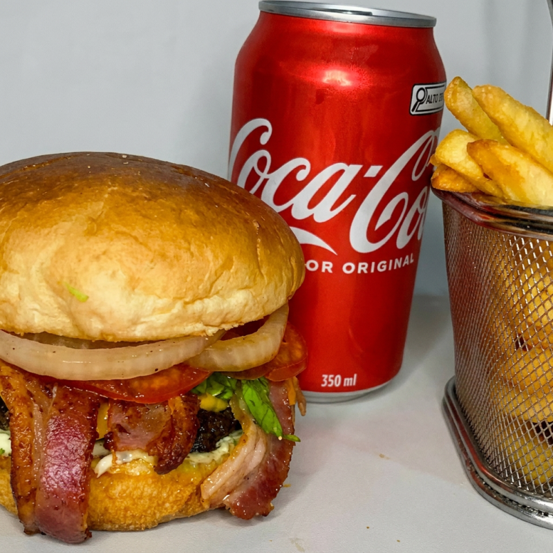 Hambúrguer artesanal com um suculento smash de 100g, com fatias crocantes de Bacon, coberto com queijo cheddar derretido em um pão selado à perfeição. Acompanha uma refrescante salada de tomate, cebola e alface americana. O toque especial fica por conta do molho barbecue e da maionese verde. Para completar, uma porção de 200g de batatas fritas crocantes e uma lata de Coca-Cola de 350ml, complementam essa experiência gastronômica inigualável.