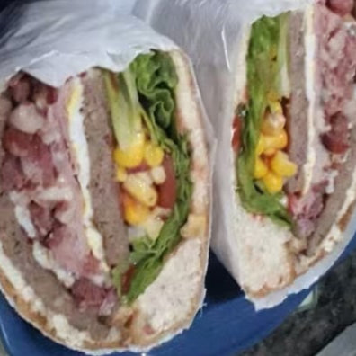 Pão de hamburguer, hamburguer, bacon, mussarela, presunto, ovo, milho, alface e tomate. ( lanche grande 4 partes) um dos mais pedidos da casa.