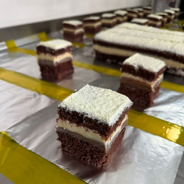 Massa de chocolate bem molhada, recheio de brigadeiro tradicional e brigadeiro branco