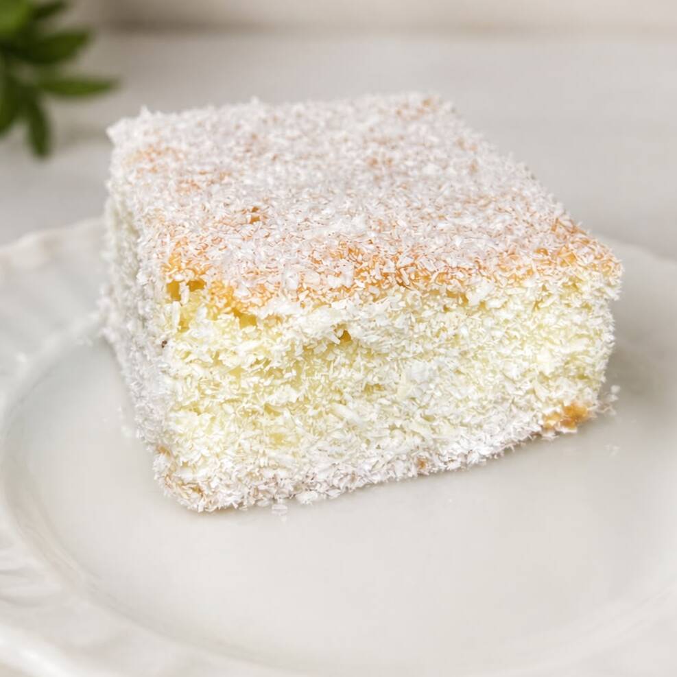 Bolo geladinho, macio e fofinho de coco, molhadinho com uma calda deliciosa e empanado no coco ralado.