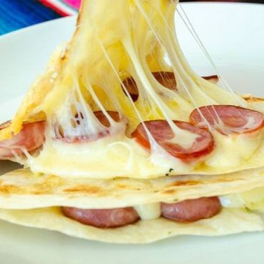 Calabresa fatiada, queijo derretido, chilli beans, alface e tomate fresco