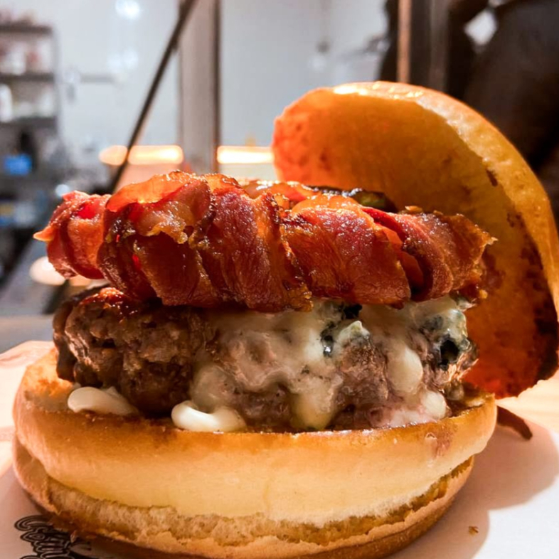 Pão brioche com hambúrguer artesanal de 150g, queijo gorgonzola, e bacon crocante enrolado na cebola, finalizado com cebola caramelizada na cerveja preta e nossa maionese especial da casa. Uma combinação marcante para quem gosta de sabores intensos!