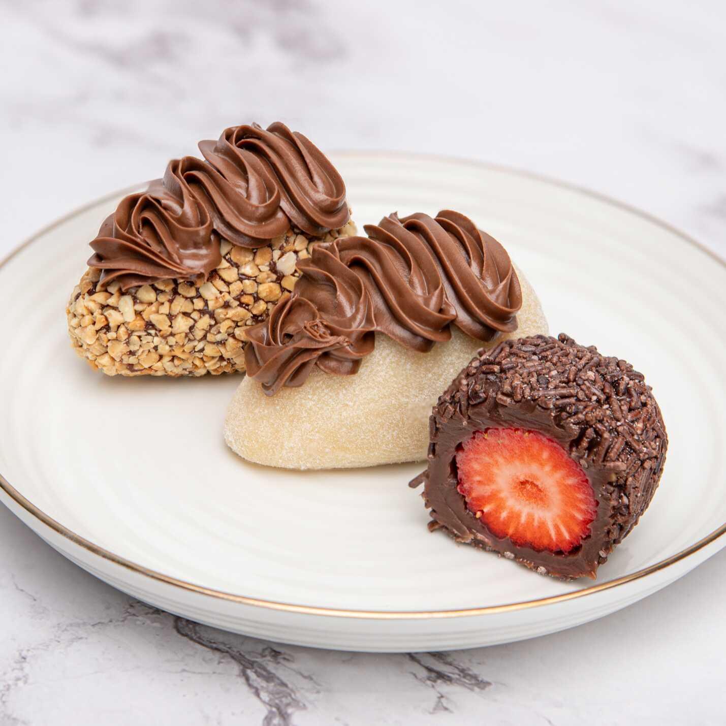 Tendo uma coxinha de ninho com creme de avelã, uma coxinha de brigadeiro 50 por cento cacau e uma coxinha tipo ferreiro com creme de avelã. Todas com morango fresco no Meio.