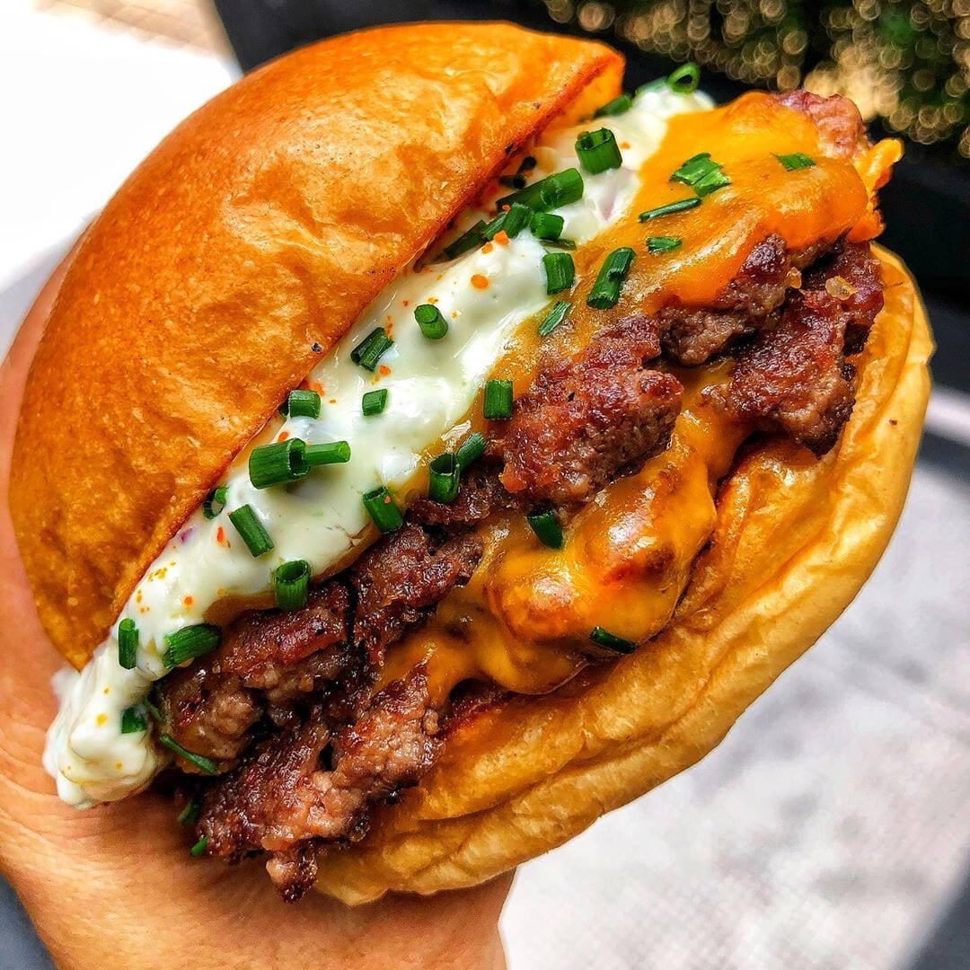 Pão de brioche, burguer de 150g, queijo cheddar, cebola caramelizada, bacon e maionese da casa