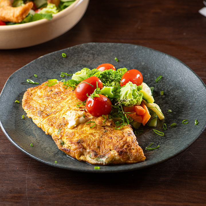 Omelete fofinha e bem servida, recheada com tomate confitado, stracciatella cremosa e manjericão fresco. Finalizada com azeite extra virgem para dar aquele toque especial.