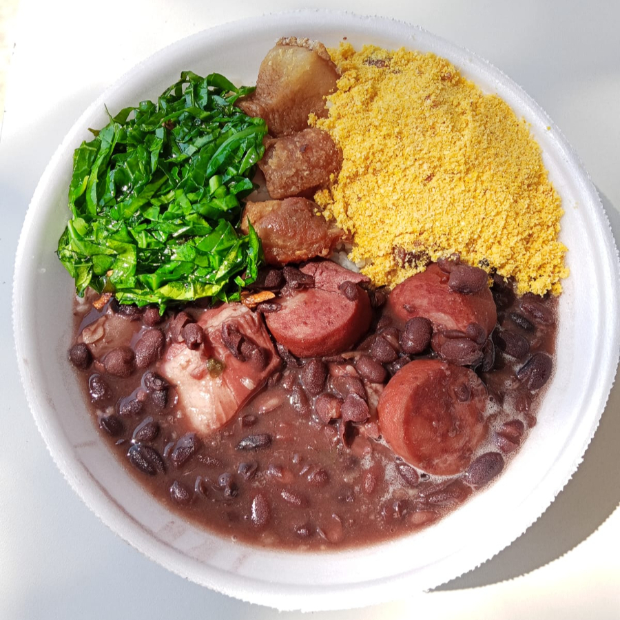 Marmita de Feijoada Magra Individual — arroz branco soltinho acompanhado de feijoada feita com carne seca saborosa, lombo macio, costelinha suculenta, linguiça calabresa e paio, tudo no caldo encorpado do feijão preto. Vem com couve refogada na manteiga, farofa dourada e torresmo crocante. Porção perfeita para matar a fome de 1 pessoa com muito sabor.