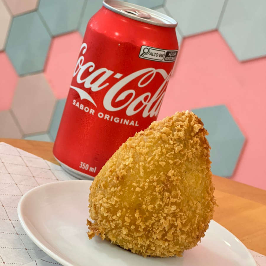 Deliciosa coxinha de frango crocante por fora e super recheada por dentro, acompanhada de uma Coca-Cola geladinha para completar.