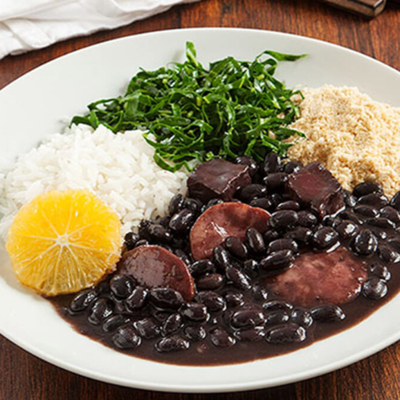 Marmitex 500ml Acompanhamentos Arroz branco, Couve, Laranja e farofinha. A feijoada da minha mãe passada de geração em geração na nossa família é de comer e lamber até os dedos, na nossa receita o pé de porco e orelha são fritos e recheados separadamente, após isso é colocado a costelinha para fritar na gordura, e a carne de sol para dessalgar e ir fritar junto com a costelinha. É retirada toda a Gordur