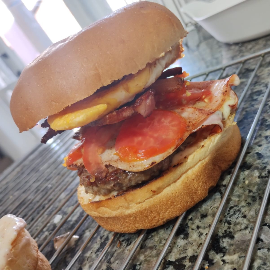 Hambúrguer Artesanal com ovo, bacon crocante, presunto, mussarela tomate e maionese de bacon'