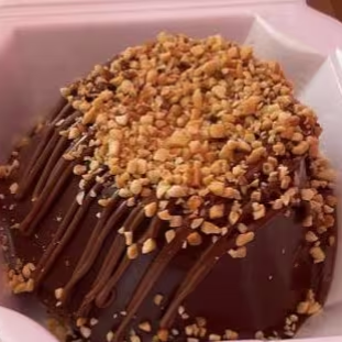 Massa branca com cobertura de brigadeiro, amendoim e creme de avelã.