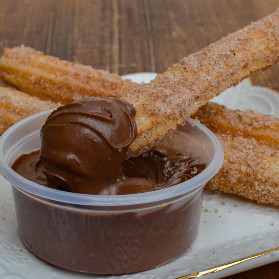 São 4 deliciosos churros tipo espanhol com um potinho cheio de Nutella para mergulhar seus churros e se lambuzar!