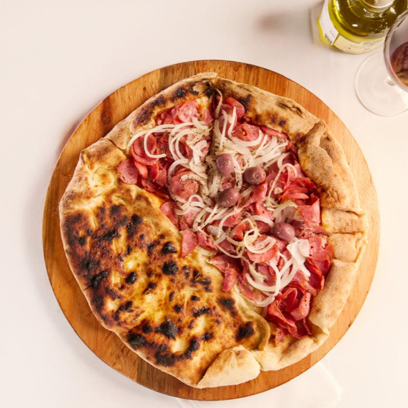 PIZZA DE CALABRESA:Molho de tomates frescos, linguiça calabresa fatiada, cebola cortada e finalizada com azeitonas pretas. Calzone - recheado de catupiry e Mozzarella.