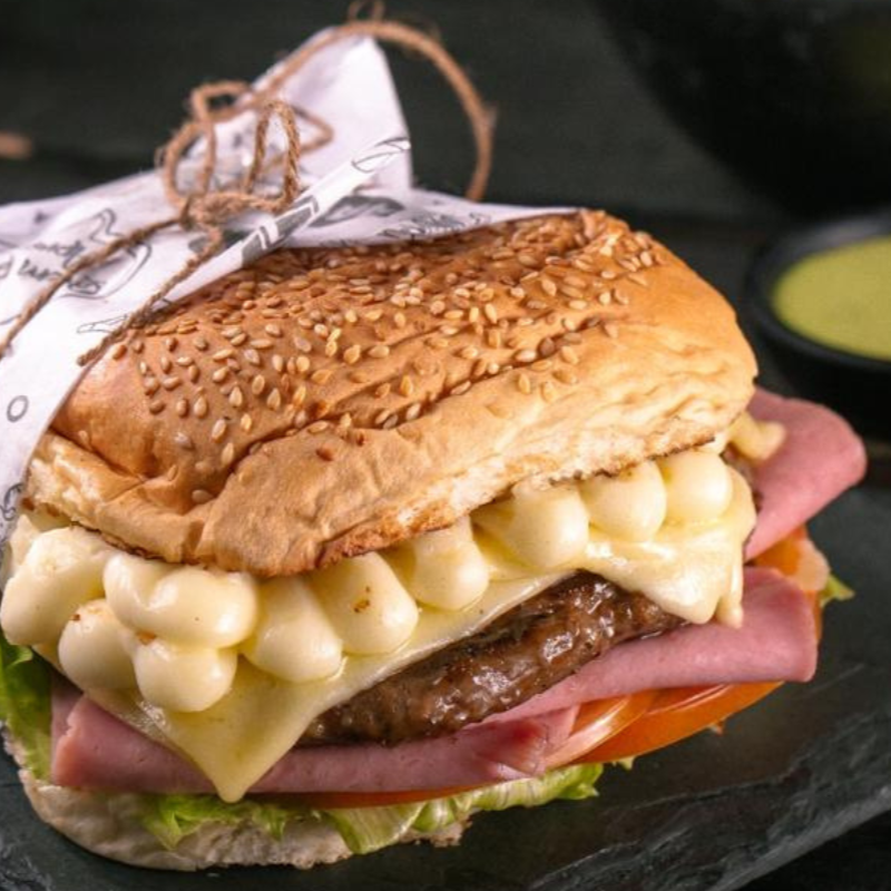 Hambúrguer Artesanal Com Presunto E Muçarela, Alface, Tomate E Milho No Pão Gergelim.