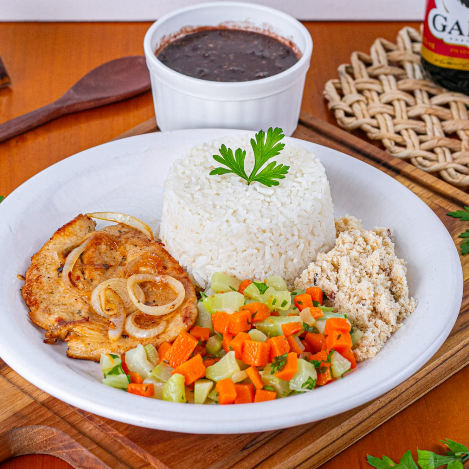 Saboroso Filé de Frango Grelhado com Salada de Legumes, acompanhado por um arroz branco soltinho, um feijão caseiro repleto de sabor, farofa crocante. Todos esses itens são servidos em uma prática marmita com aproximadamente 600gr, nossa embalagem vai ao microondas.