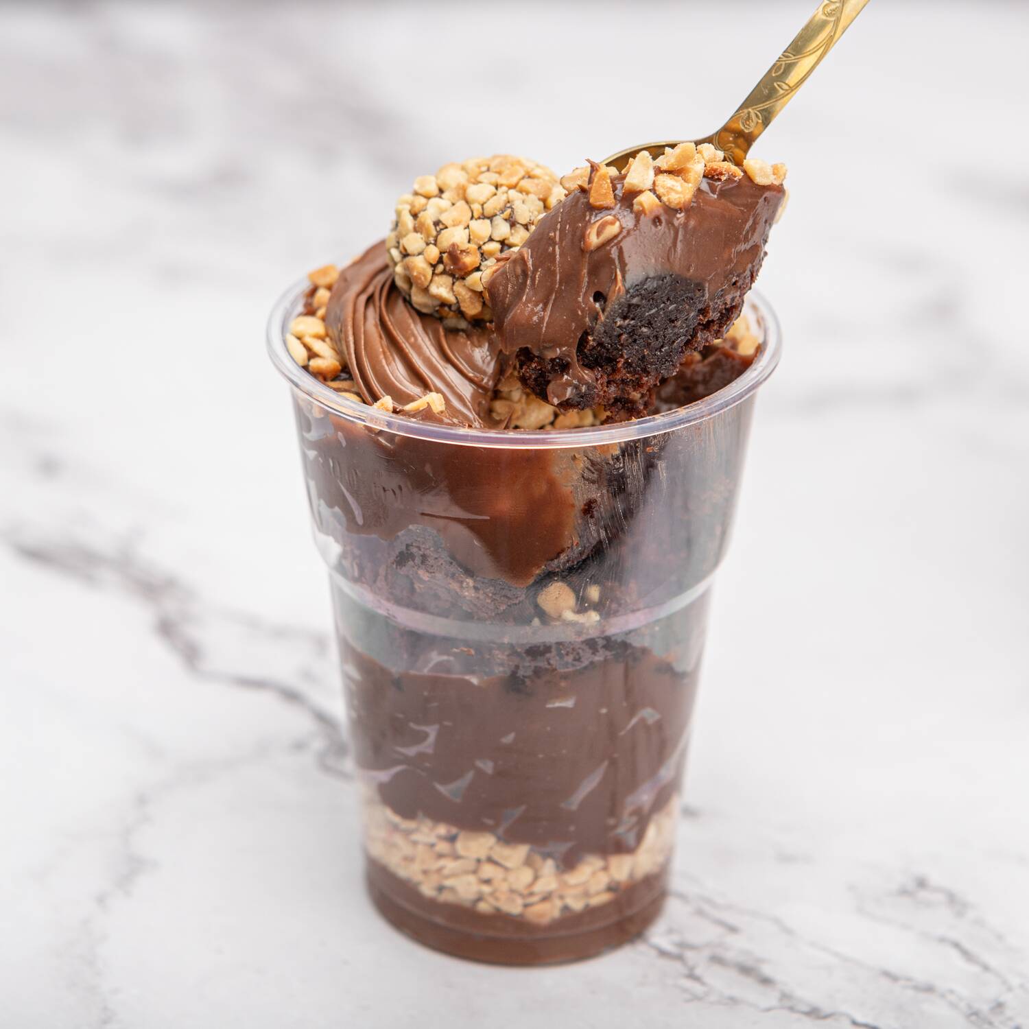camadas de creme de avelã super cremoso, amendoim crocante e torrado, nosso brigadeiro de cacau, brownie tradicional bem molhadinho… e pra fechar, mais brigadeiro, creme de avelã e avelãs por cima.