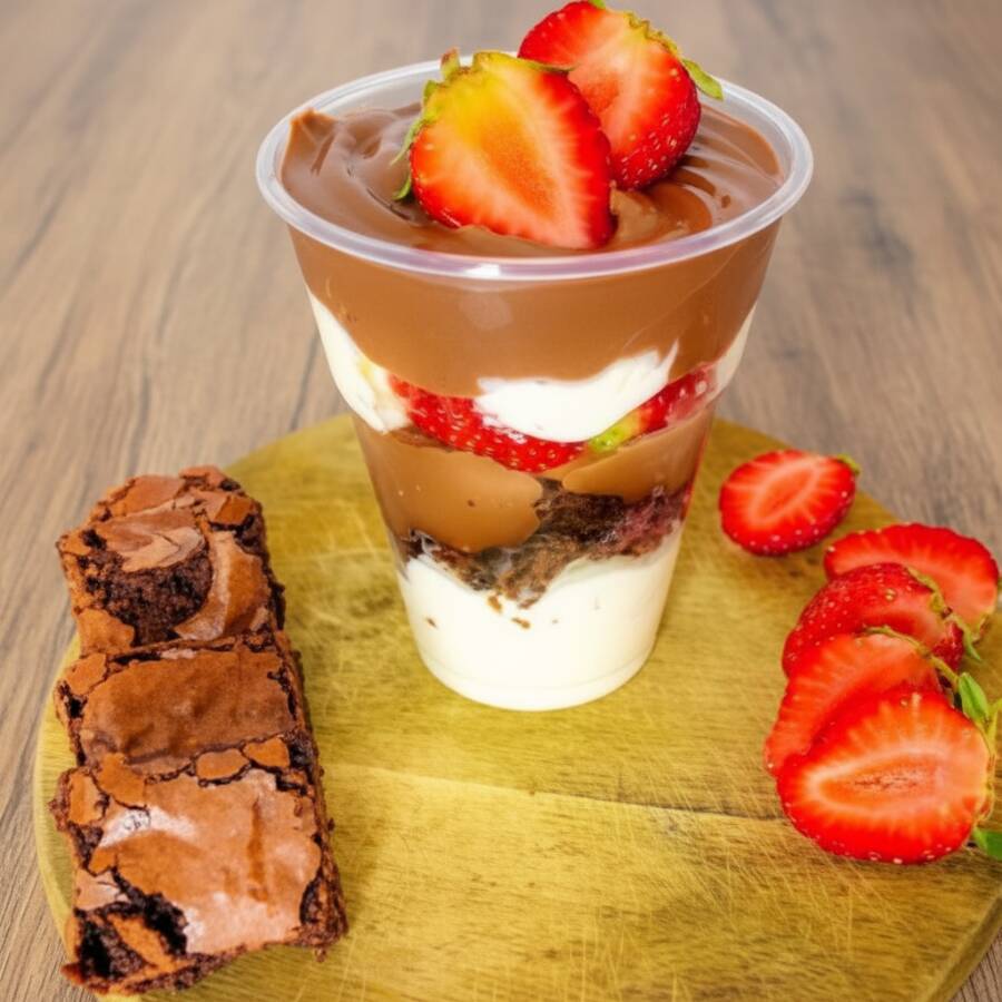 Copo da felicidade composto por nosso delicioso mousse artesanal de Ninho, brownie artesanal de chocolate, camadas de brigadeiro cremoso e morangos (200ml)