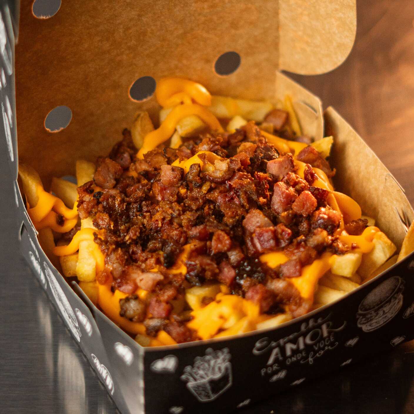 Batata Frita Crocante Coberta com cheddar cremoso e Bacon em Cubos saboroso.