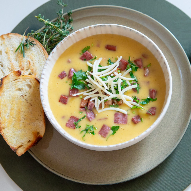 Caldo cremoso de mandioca com calabresa defumada e bacon crocante, preparado com nosso fundo especial da casa e finalizado com salsa e cebolinha fresca. Acompanha nosso pão torrado com um toque de manteiga de garrafa. Sabor marcante, feito com carinho de roça. Embalagem de 500 ml