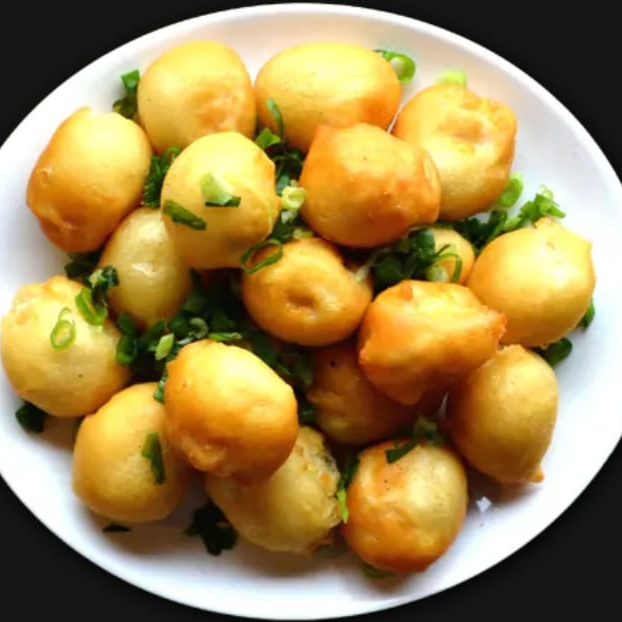 bolinho de camarão empanado e frito salpicado com alho e cebolinha.
