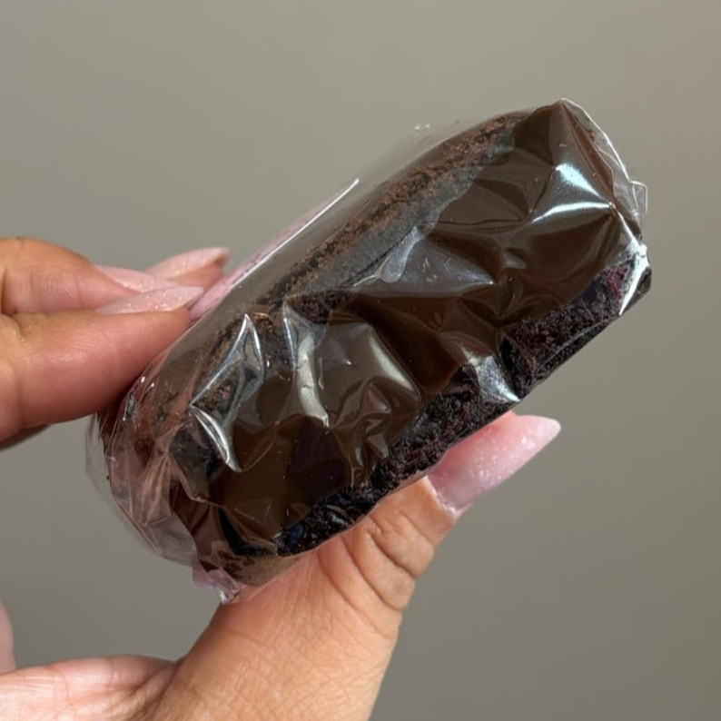 Um pedaço de brownie 50% cacau cortado ao meio e recheado com brigadeiro cremoso — simples, intenso e irresistível! 😍