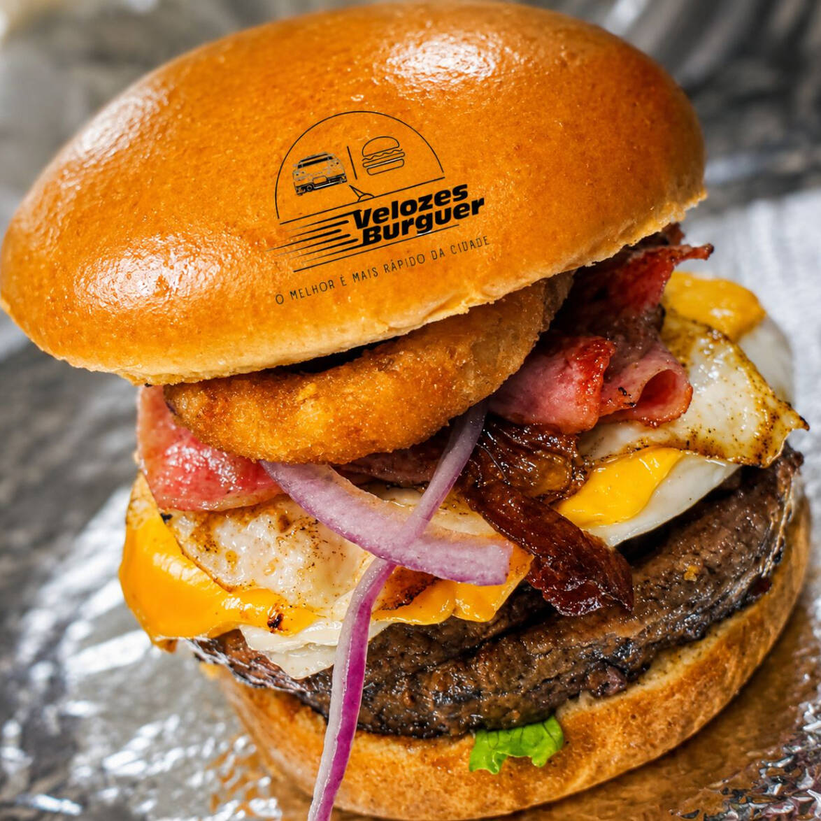 Pão Brioche, 2 Carnes Picanha 120gr , Molho Especial, Ovo, Bacon, Presunto, Queijo Prato, Queijo Cheddar, Cebola, Cebola Empanada, Tomate E Alface