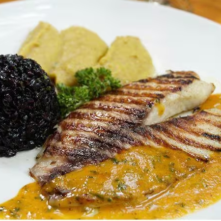 Filé de tilápia ao molho mediterrâneo, acompanhado de purê de banana e arroz negro
