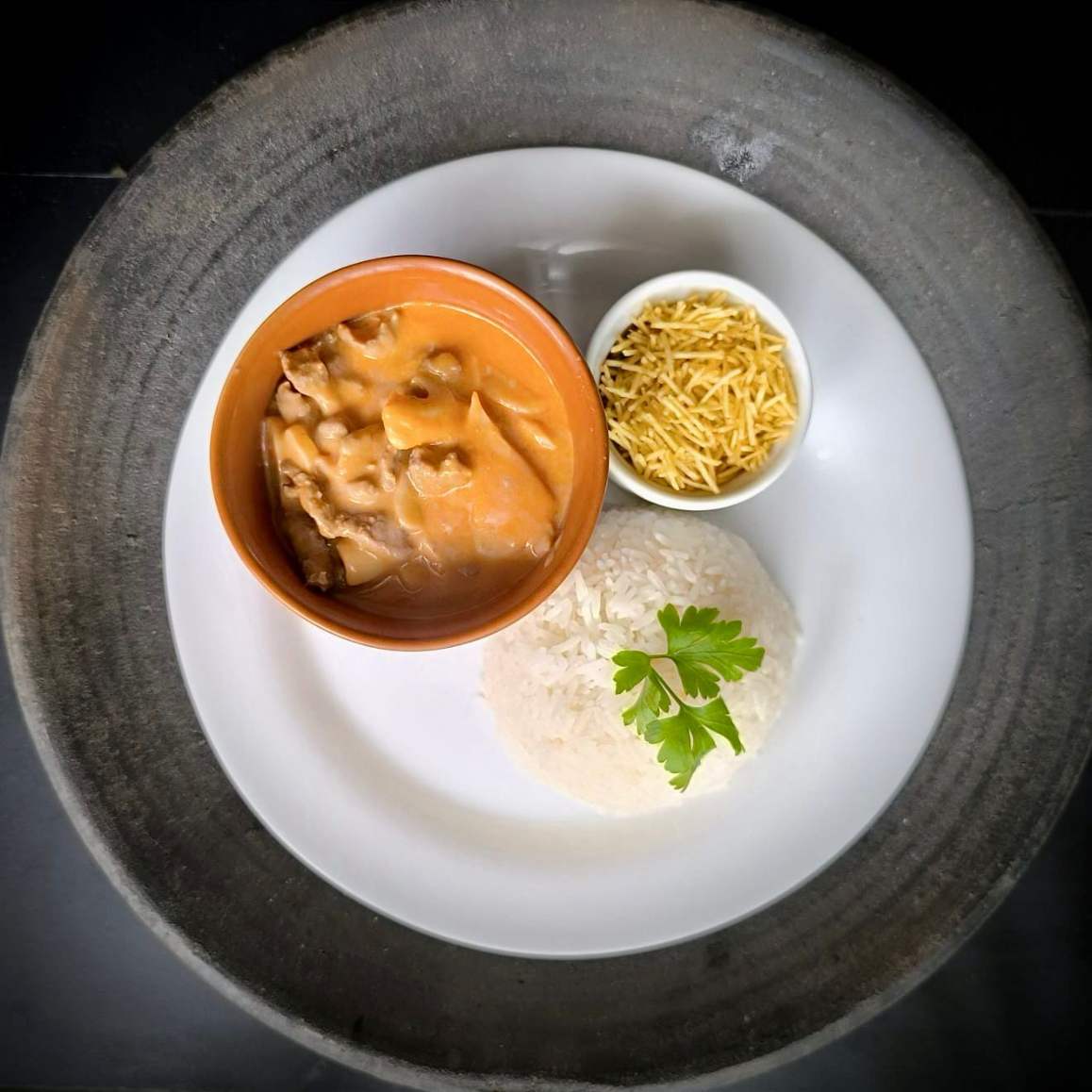 Iscas de carne (alcatra) banhadas em um cremoso molho à base de creme de leite, tomates frescos e champignons laminados. Acompanha batata palha extra fina e arroz branco. Todos os itens são enviados separadamente.
