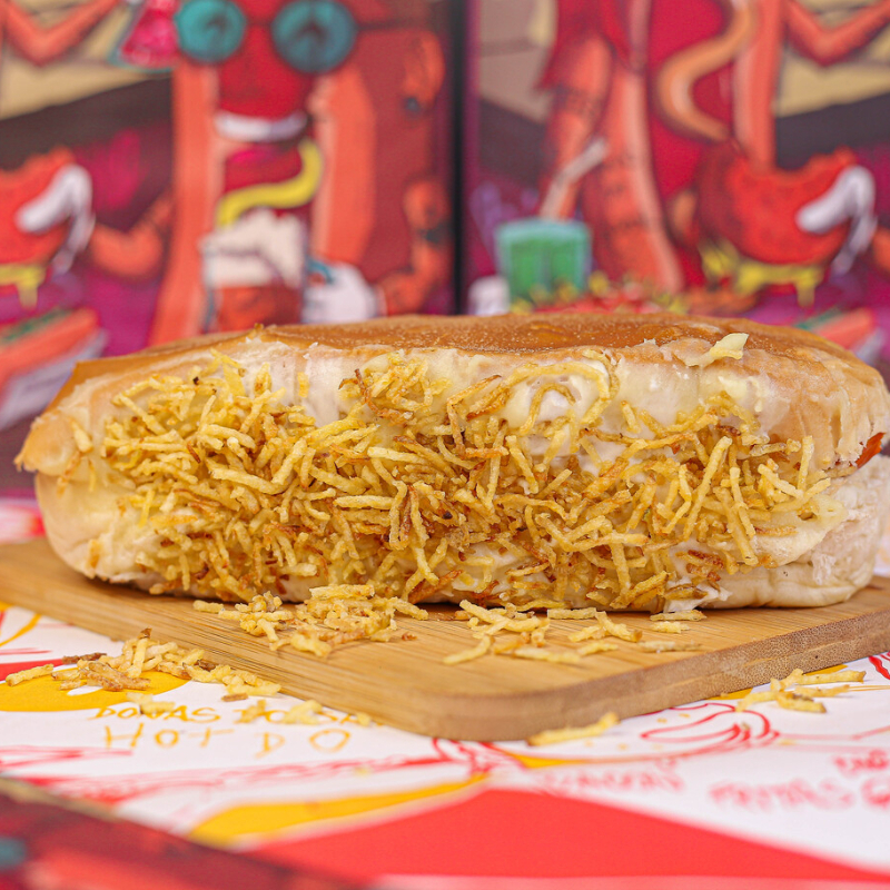 Pão super macio de 20cm, 2 salsichas perdigão, batata palha, catchup, maionese, mostarda, maionese de alho, finalizado com purê de batata com queijo e batata palha. Serve 1 pessoa