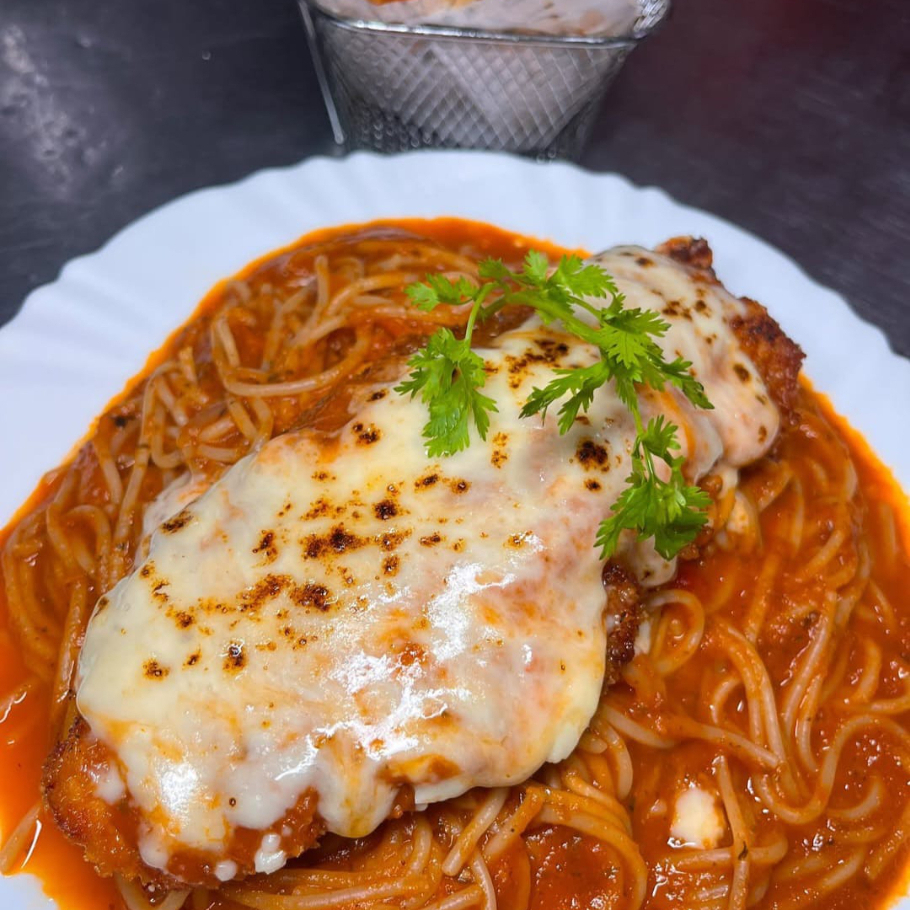 Delicioso almoço de filé de frango à parmegiana, acompanhado de macarrão ao molho sugo e batatas fritas.