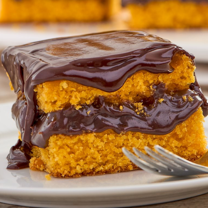 Delicioso bolo de cenoura caseiro com uma generosa cobertura de chocolate ao leite.