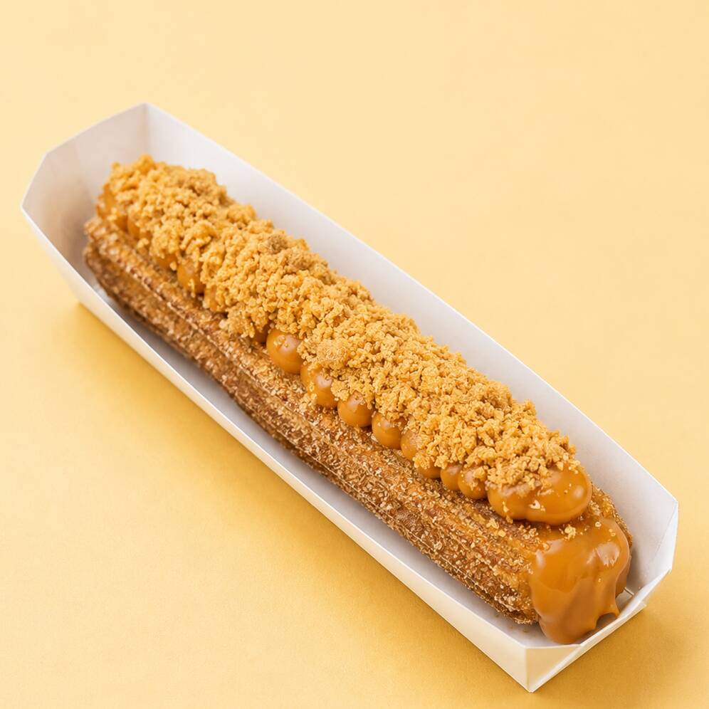 Churros crocante por fora, macio por dentro, recheado e finalizado com creme de paçoca e pedacinhos irresistíveis. Uma explosão de sabor a cada mordida!