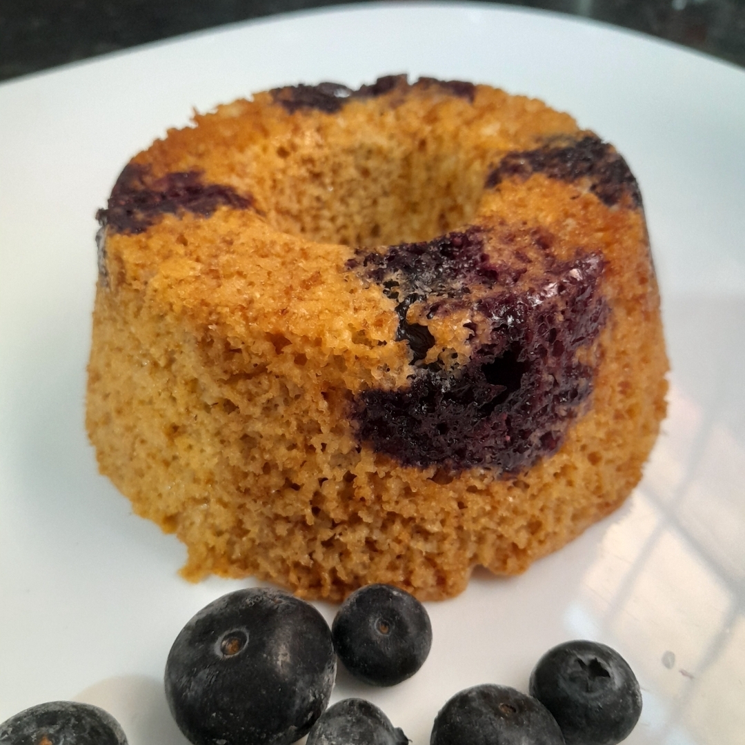 Mini Bolo de iogurte com mirtilos. Na receita contém, farinha de aveia, ovos, oleo de coco, açucar mascavo, iogurte natural e mirtilos.