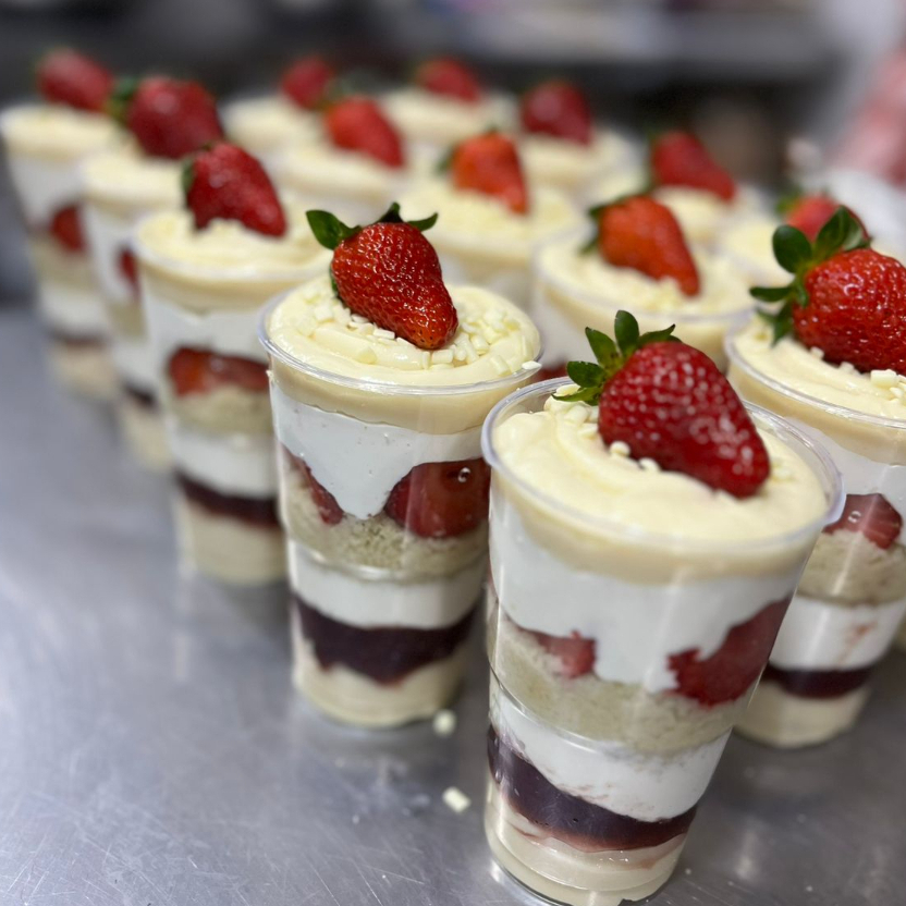 Um delicioso copo da felicidade com brigadeiro de ninho e creme de ninho com pedaços de morangos frescos