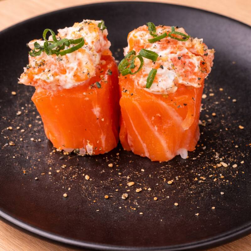 Arroz japonês envolvido com lâmina de salmão, pasta de salmão, cebolinha e gergelim moído.